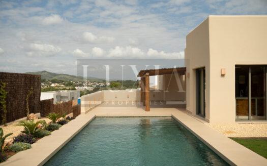 Villa ibicenca de lujo en venta en Jávea con piscina y jardín mediterráneo.