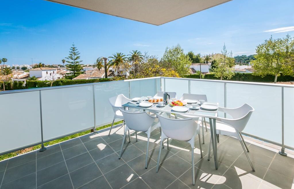 Terraza con mesa y sillas blancas