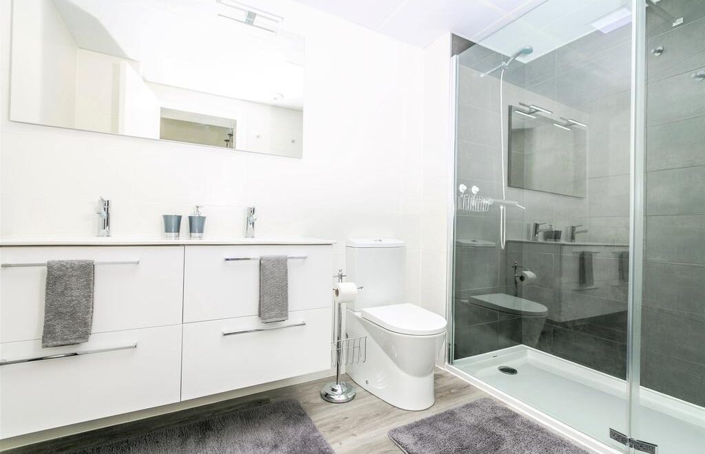 Baño moderno con ducha y lavabo.