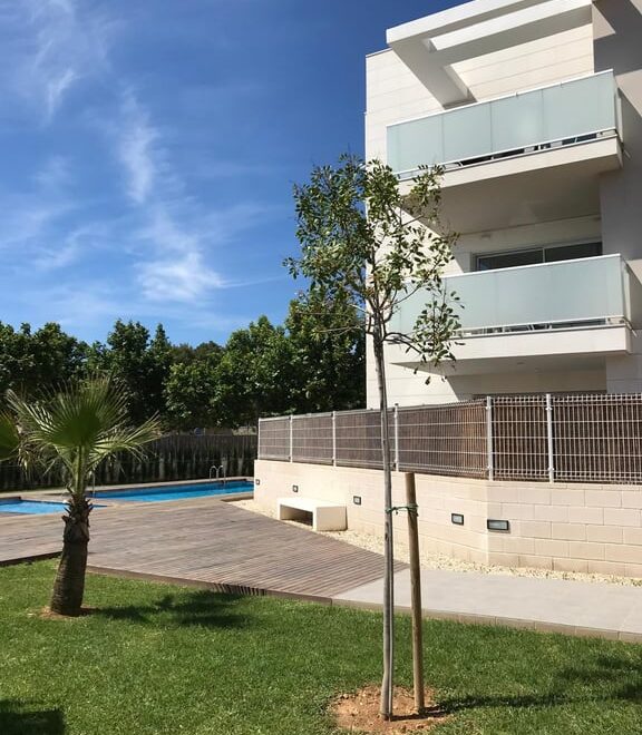 Edificio moderno con piscina y árboles.