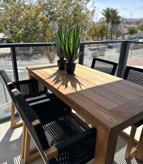 Mesa de madera con sillas negras.