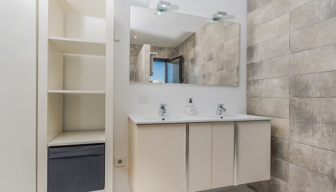 Baño moderno con espejo y muebles.
